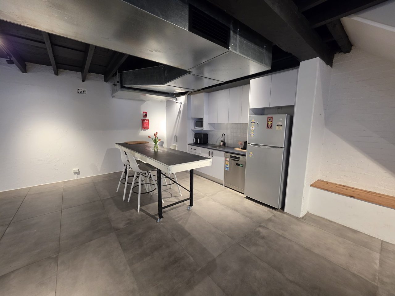 The kitchen and main room in one frame — island table, appliances and the open floor.