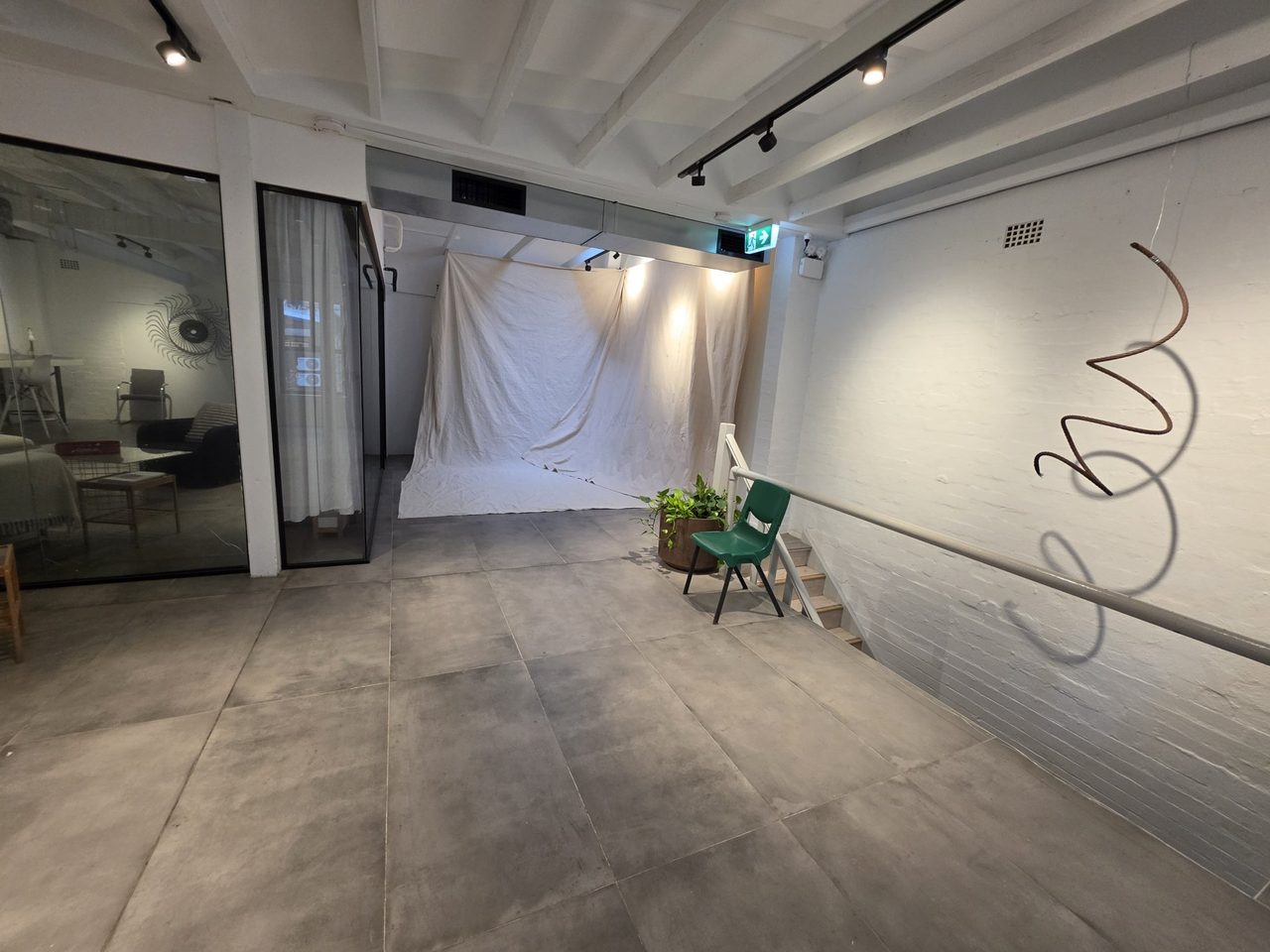 The muslin backdrop hung wall-to-floor, green chair placed.