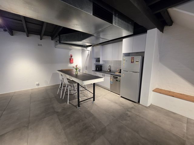 The kitchen and main room in one frame — island table, appliances and the open floor.