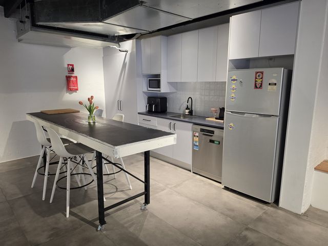 The island table set with tulips, kitchen bench and full-height fridge behind.