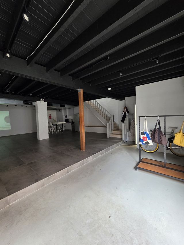 The entry corner from the platform — coat racks, bike parking, the door beyond.