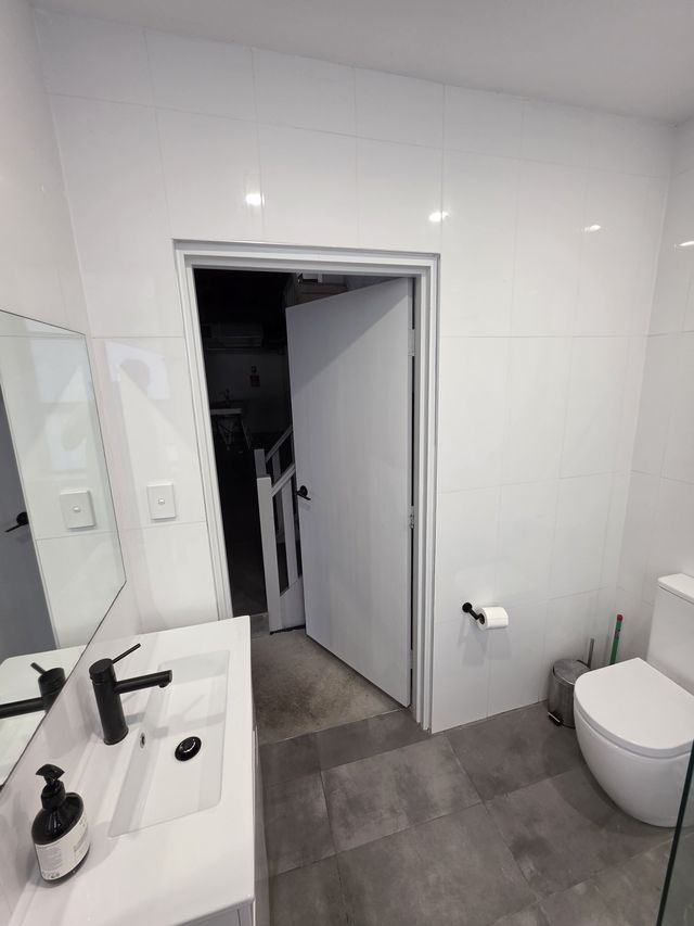 The bathroom — walk-in shower, black tapware.