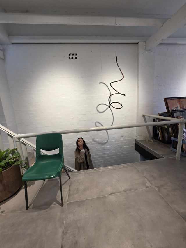 Coming up the loft stairs past the green chair and wall sculpture.