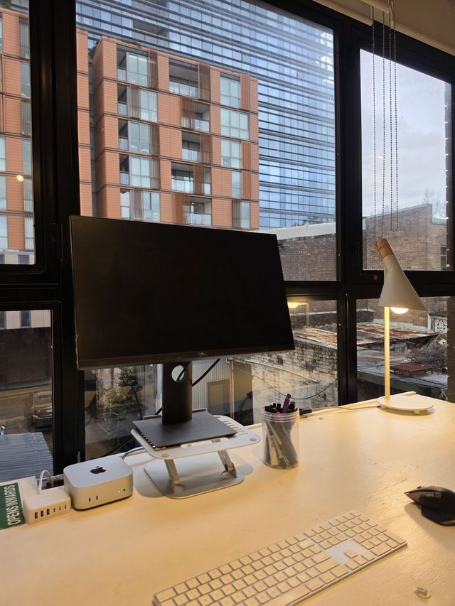 The view from the desk — keyboard, Mac mini, towers across the street.